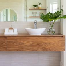 Bathroom Features a Floating Double Wood Vanity With Vessel Sinks and Chrome Fixtures