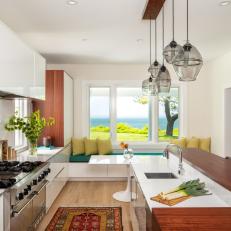 Bright Kitchen Features Modern Cabinets, a Wood Island and Hanging Glass Pendants 