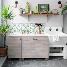 Bright Mudroom Features a Utility Sink and a Set of Wood Cabinets With a Tropical Tile Backsplash