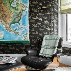Eclectic Home Office Features a Black, Patterned Wallpaper and a Modern Armchair
