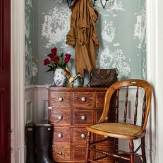 Traditional Foyer Features Blue Wallpaper, a Walnut Chest Below Metal Hooks and an Antique Armchair
