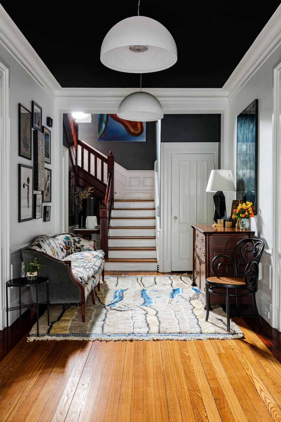 An Eclectic Foyer Features a Black Ceiling, Modern Light Fixtures and a
