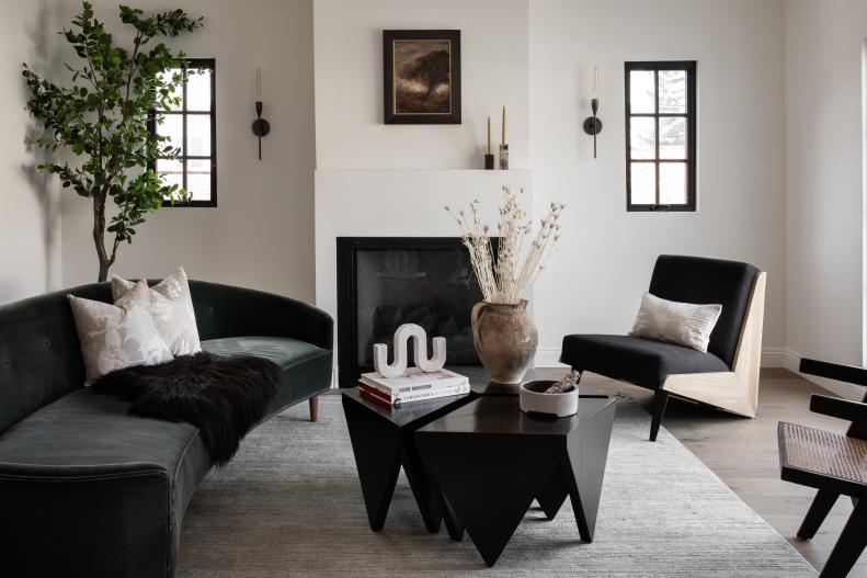 Narrow windows flank the gas fireplace in the living room. Black wall sconces complement the clean lines of the windows, hearth and mantel. 