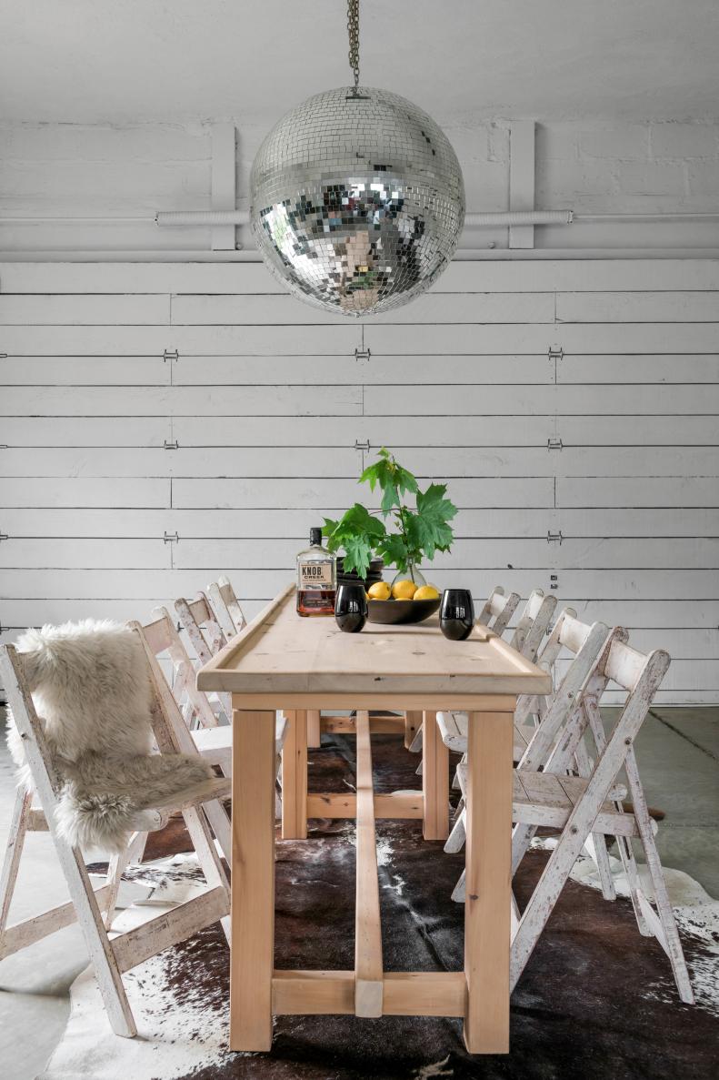 Steve can entertain friends and family indoor-outdoor style thanks to this fully functional garage door. For an element of surprise, the Scandinavian farmhouse table is paired with a 24" diameter mirror ball.