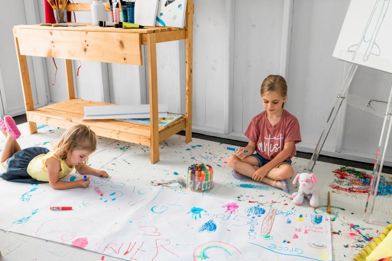 With worry-free carpet tiles to perch on, both sisters also set up shop on the floor to create banners and posters with rolls of white paper and markers.
