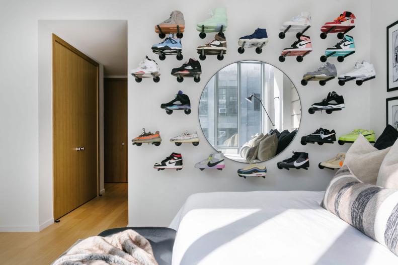 A white wall features two dozen pairs of colorful  sneakers.