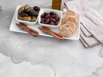 Appetizers on a white and gray watercolor-patterned countertop.