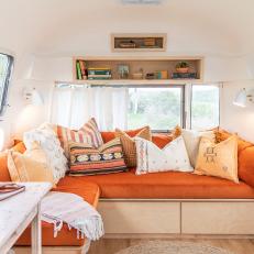 Built-In Sectional With Orange Cushions for a Tiny Home