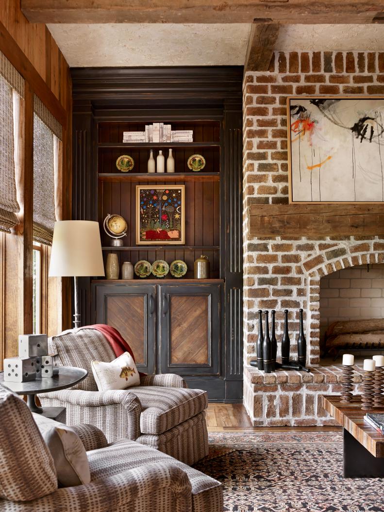 This rustic family room features high ceilings and a brick fireplace.