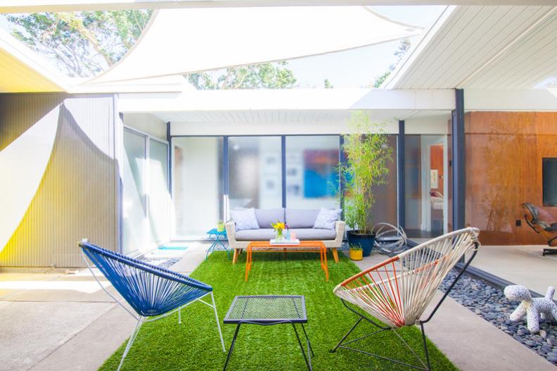 This modern home features a courtyard with Acapulco chairs.