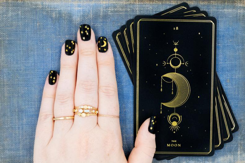Hand Resting on Moon Tarot Card Displaying Nails With Stars and Moon 