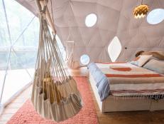 A bedroom and swing seat inside of a domed treehouse