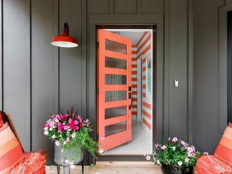 Open Orange Front Door Welcomes Visitors Into Striped Foyer