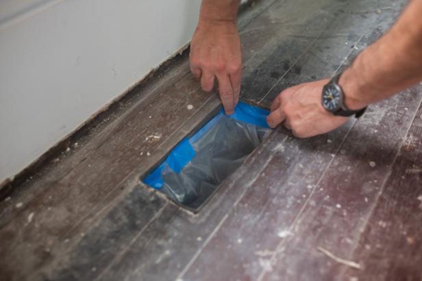 准备重新装修硬木地板时，用油漆工胶带覆盖地板通风口。