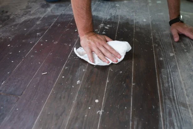 Wipe down floors with a damp rag to remove all debris and dust. Let it dry fully before sanding.