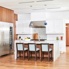 Brown and White Open Plan Kitchen With Blue Stools 