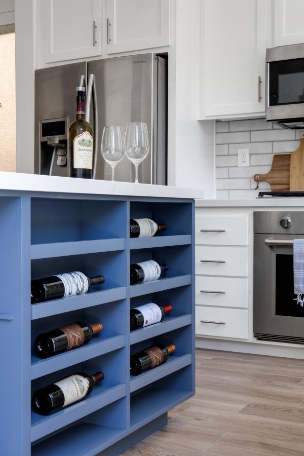 Blue kitchen island has shelves for eight wine bottles.