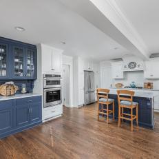 Spacious Cape Cod Kitchen With Blue and White Cabinets and Hardwood Floors