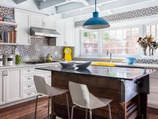 This bright kitchen features mosaic tile and a blue pendant light.