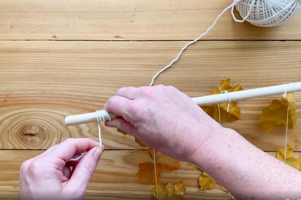 Make the hanger with twine or cord. Wrap a couple of inches of twine around the ends of the dowel rod and tie it off with a knot in the back. Do this for both sides.