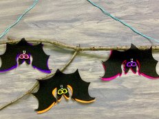 Three Felt Bats Hanging Upside Down in a Tree Branch 