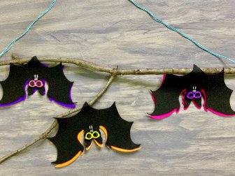 Three Felt Bats Hanging Upside Down in a Tree Branch 