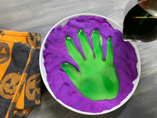 Take out the kinetic sand mold from the freezer and slowly pour the melted wax into the mold. TIP: Pour the wax close to the mold so the wax doesn’t create an indent in the sand.