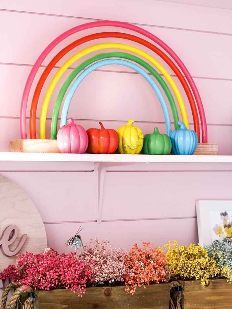 Ashley Wilson of At Home With Ashley used PVC pipes and spray paint to create this colorful rainbow arc. Spray painted pumpkins bring the Halloween.