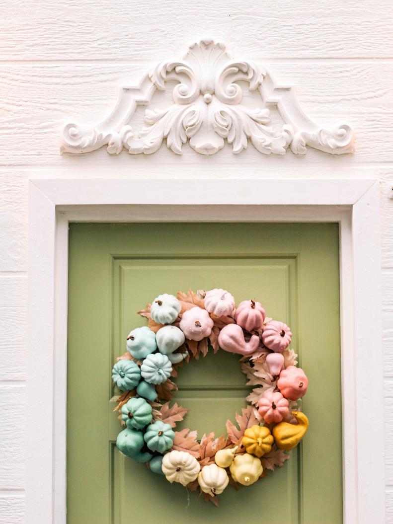 A rainbow pumpkin wreath — pastel style. At Home With Ashley's sweet masterpiece is a DIYers dream. Plus, it pops against a sage green door.