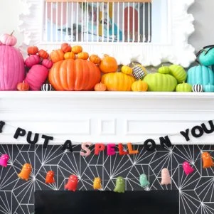 That black cobwebby pattern surrounding the fireplace is actually peel-and-stick wallpaper. Kailo Chic's Kara Whitten paired it with colorfully painted pumpkins and hanging banners to complete the fun and festive look.