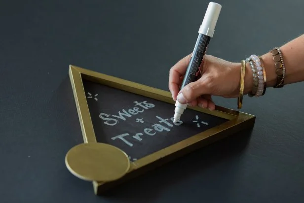 Write a custom message on the new DIY sign with a chalk marker.
