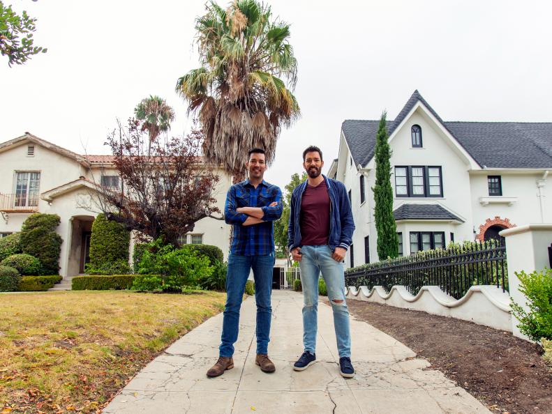 Left to Right: Jonathan Scott and Drew Scott stand on the driveway separating Drew's own family home with the house that Jonathan will renovate, as seen on Brother Vs Brother.