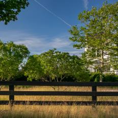 Black Fence Surrounding Beautiful White Farmhouse