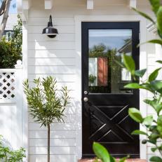 White Farmhouse Cottage With Contrasting Black Door