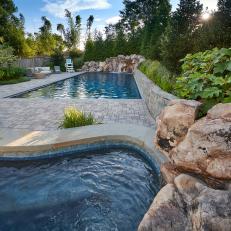 Two Pools Feature Cobblestone Decking and Boulder Waterfalls