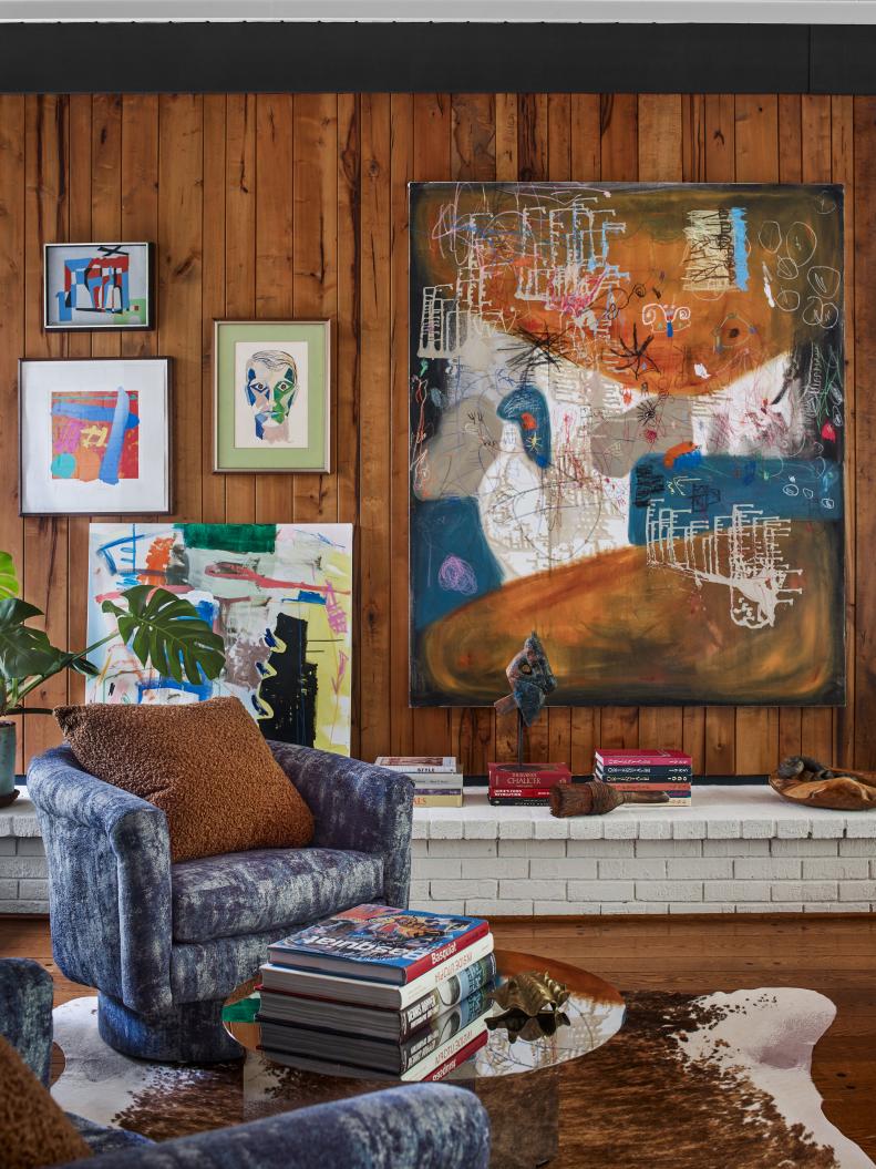 This living room includes artwork on a wood-paneled wall.