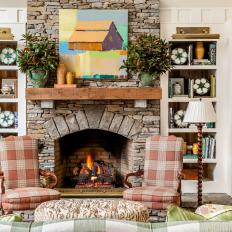 Traditional Living Room With Stone Fireplace, Built-In Shelves and Plaid Armchairs 
