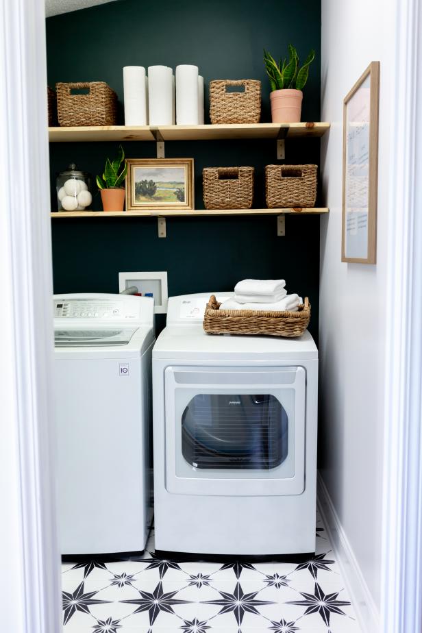 Remodeling on a budget? We gave outdated floors a refresh by painting and stenciling ceramic tile. To complete the look, we made shelves from a piece of wood and inexpensive brackets from the craft store. The back wall of this laundry room is painted Black Evergreen by Behr.