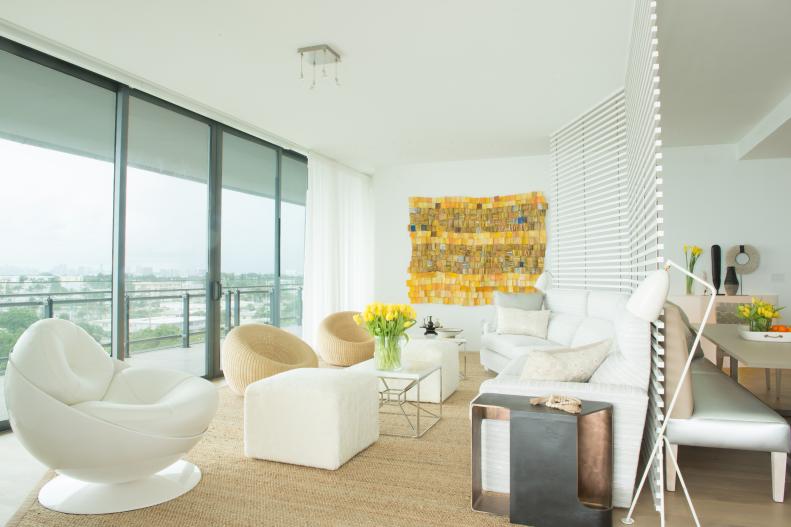 This living room features white furniture and yellow tapestry.