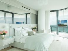 This main bedroom features an ocean view and white bedding.