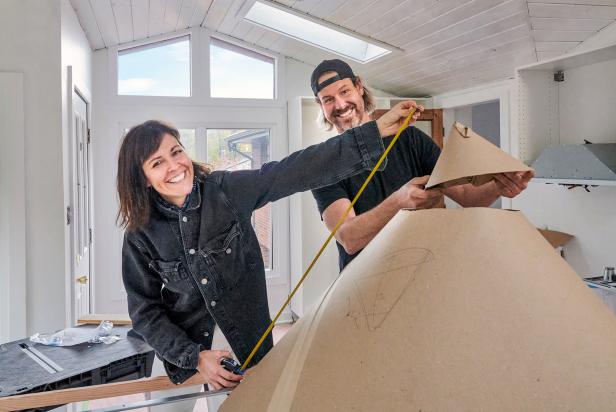 As seen on HGTV's Home Again with the Fords, brother and sister duo Steve (R) and Leanne (L) Ford measure the dimensions of a cardboard model of a custom light fixture in Kelly Jo Reuter's home in Pittsburgh, Pennsylvania. The home was the house Kelly's mom grew up in, and Kelly and her family are updating it for themselves.