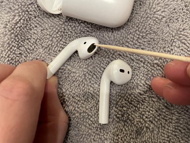 Cleaning a dirty pair of Apple AirPods.