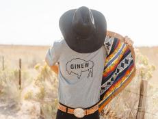 A Native American man wearing a cowboy hat and a Ginew t-shirt