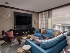 Neutral room with tall entertainment center and teal leather seating.