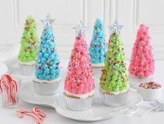 Ice cream cones turned upside-down provide an ideal structure to assemble sweet Christmas tree cupcake toppers. Whether it's traditional greens and reds or fun, unconventional pinks and blues, any festive color palette will make these the star of the dessert table.