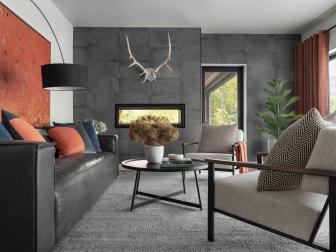A mix of neutral tones in the furniture, rug and wall color is given a dash of warmth with paprika toned accessories and artwork. The modern living space feels fresh, sleek and inviting.