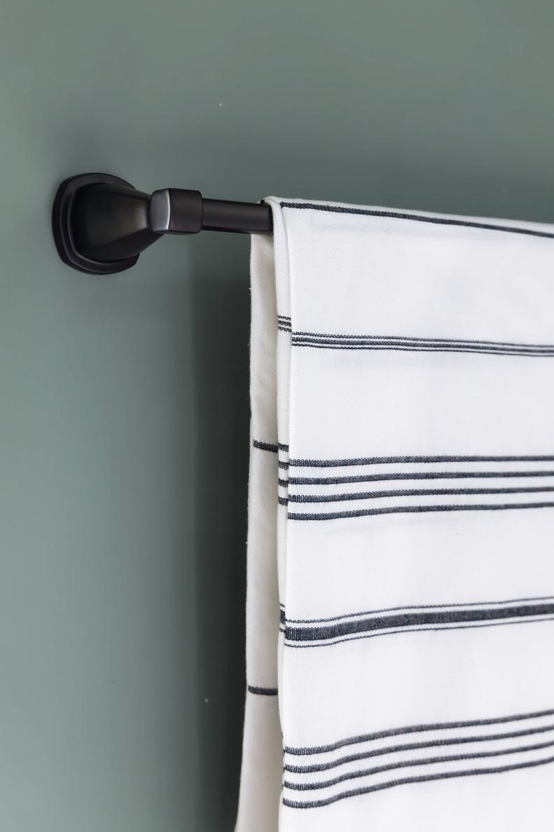 A spacious contemporary towel bar on the wall above the freestanding tub keeps towels within easy reach. 