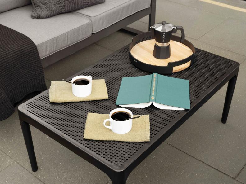 A black, metal coffee table adds an industrial element and creates ample room for morning coffee and your favorite book.
