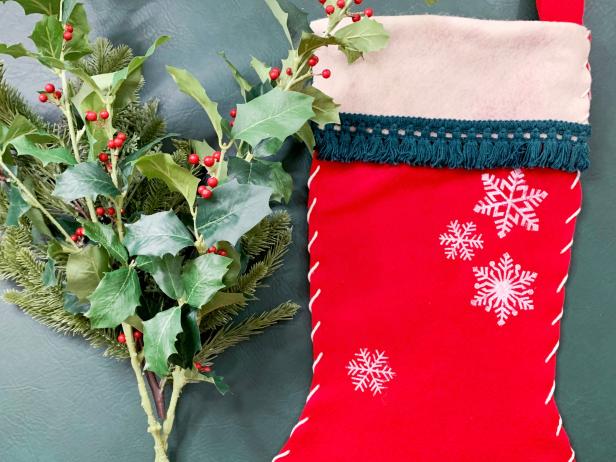 Use tissue paper, batting or scrap paper to fill the stocking. Rip the paper into small pieces, crumple them up and then carefully place them inside the stocking. Add faux greenery popping out of the stocking for a true festive feel. Hang on a front door or inside your home to spread some cheer!