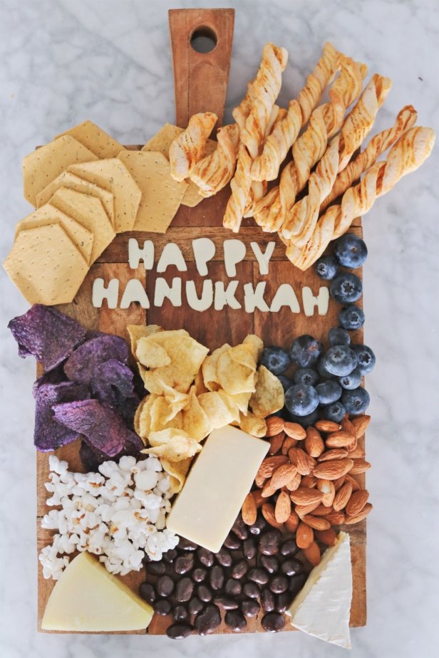 Cheese Platter With Snacks and Cheese That Spells Out "Happy Hanukkah"